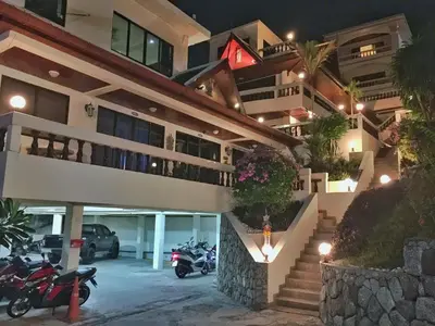 a building with motorcycles parked in a parking lot at night at Blue Sky Residence in Patong Beach