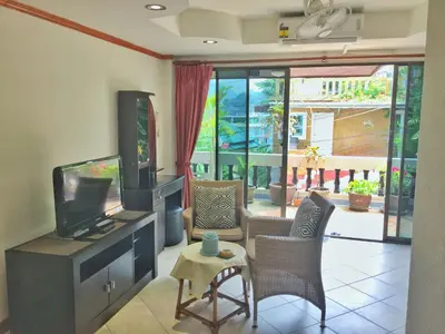 a living room with a flat screen tv and chairs at Blue Sky Residence in Patong Beach
