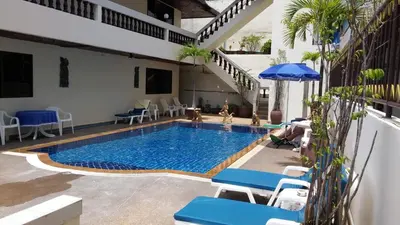 a swimming pool with blue chairs and an umbrella at Blue Sky Residence in Patong Beach