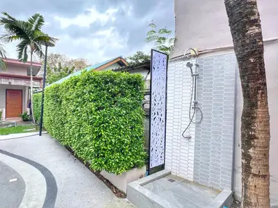 a bush with a shower in it next to a building at The Passion Nest - SHA Plus Certified in Phuket Town