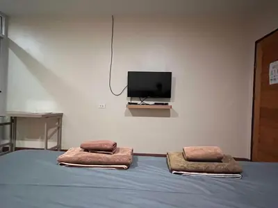 a bedroom with a bed with two pillows and a tv at The Passion Nest - SHA Plus Certified in Phuket Town