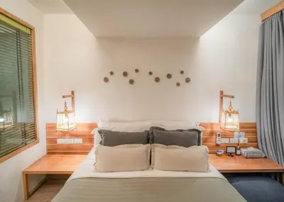 a bedroom with a large bed with two pillows at The Parlour Krabi in Klong Muang Beach