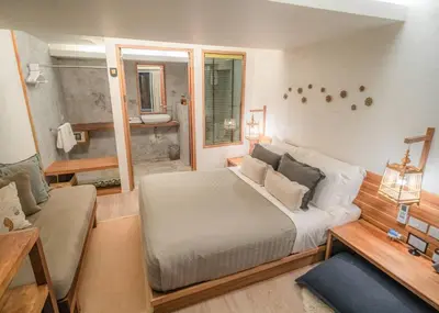 a bedroom with a large bed and a bathroom at The Parlour Krabi in Klong Muang Beach