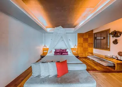 a bedroom with two beds with red and blue pillows at The Parlour Krabi in Klong Muang Beach