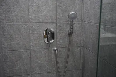 a shower with a shower head on a wall at Heaven Apartments in Patong Beach