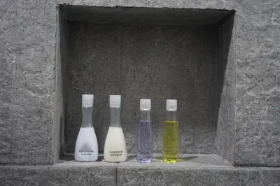three glass bottles sitting in a stone box at Heaven Apartments in Patong Beach