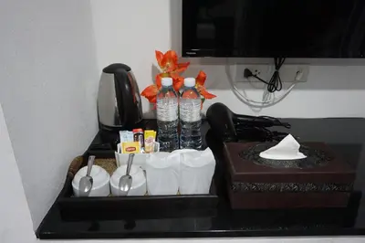 a tray with water bottles and utensils on a table at Heaven Apartments in Patong Beach