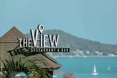 a sign for the view restaurant and bar with a view of the water at The View Rawada Phuket in Rawai Beach