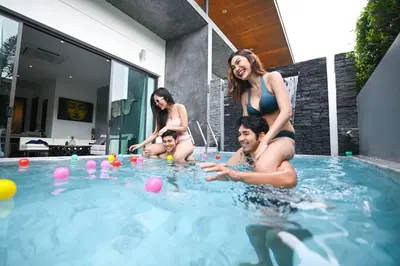a group of people playing in a swimming pool at The Infinity Private Pool Villa in Phuket Town