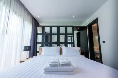 a bedroom with a large bed with two towels on it at The Infinity Private Pool Villa in Phuket Town