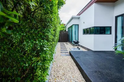 a ivy covered wall next to a house at The Infinity Private Pool Villa in Phuket Town