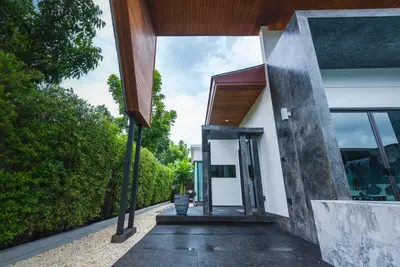 an external view of a house with a glass door at The Infinity Private Pool Villa in Phuket Town