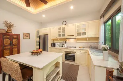 a kitchen with a table with a bowl of fruit on it at VILLA LETI 22 meters Pool Naiharn Beach in Rawai Beach