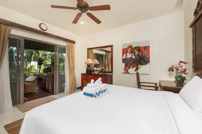 a bedroom with a white bed with a ceiling fan at VILLA LETI 22 meters Pool Naiharn Beach in Rawai Beach