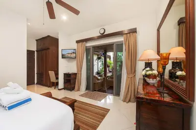 a bedroom with a bed and a desk with a mirror at VILLA LETI 22 meters Pool Naiharn Beach in Rawai Beach