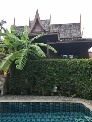 a resort with a swimming pool in front of a building at Ban Elephant Blanc Bungalow in Kata Beach