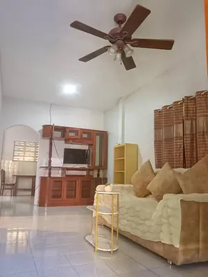 a living room with a couch and a ceiling fan at Ban Elephant Blanc Bungalow in Kata Beach