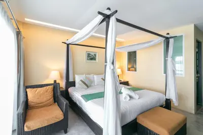 a bedroom with two beds and a canopy bed at Baan PhuAnda Phuket in Phuket Town