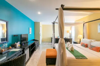 a bedroom with a canopy bed and a television at Baan PhuAnda Phuket in Phuket Town