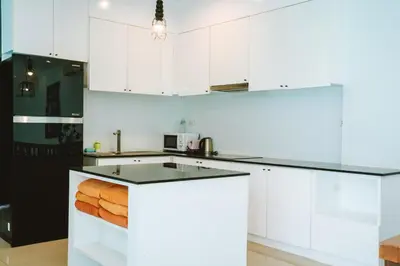 a kitchen with white cabinets and a black refrigerator at Layantara Villas in Layan Beach