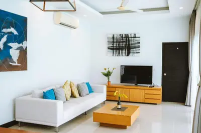 a living room with a white couch and a tv at Layantara Villas in Layan Beach