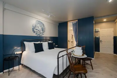 a bedroom with a bed and a table and a chair at Blu Monkey Boutique Phuket Town in Phuket Town