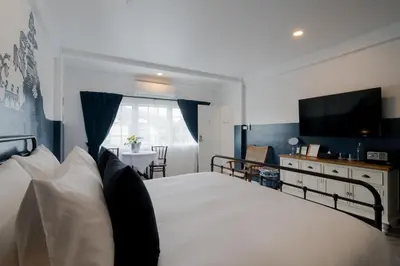 a bedroom with a bed with a television and a table at Blu Monkey Boutique Phuket Town in Phuket Town