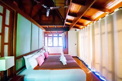 a bedroom with a large bed with pink pillows at Luxury 4 bedrooms Villa with Seaview Infinity Pool overlooking Surin Beach in Surin Beach
