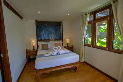 a bedroom with a bed with a bow on it at Luxury 4 bedrooms Villa with Seaview Infinity Pool overlooking Surin Beach in Surin Beach