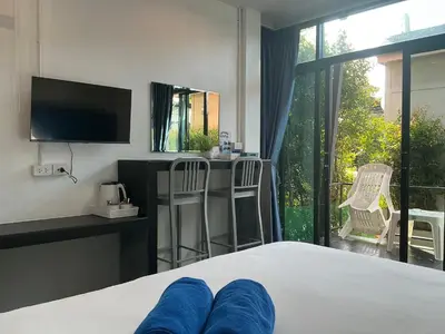 a bedroom with a bed with a television and a balcony at Loma Place in Ao Nang Beach