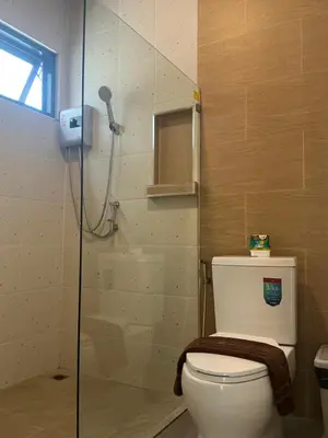 a bathroom with a shower with a toilet and a glass door at Loma Place in Ao Nang Beach