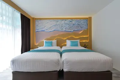 two beds in a room with a painting on the wall at T2 Ao Nang Krabi in Ao Nang Beach
