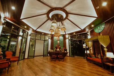 a large room with a ceiling with a table and chairs at Navatara Phuket Resort in Rawai Beach