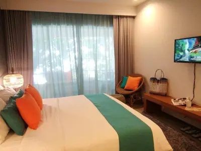 a hotel room with a bed and a television at Bliss Resort Krabi in Klong Muang Beach