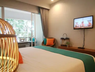 a bedroom with a bed and a tv on the wall at Bliss Resort Krabi in Klong Muang Beach
