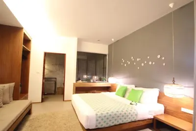 a bedroom with a large bed with green pillows at Bliss Resort Krabi in Klong Muang Beach
