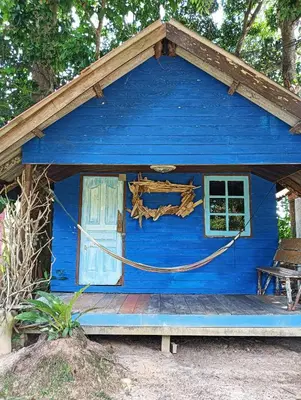 a blue house with a door and a bench at Ko Yao Noi Sabai Bungalows in Ko Yao Noi