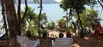 two white chairs sitting in front of the water at Camp Hadee Koh Yao Noi in Ko Yao Noi