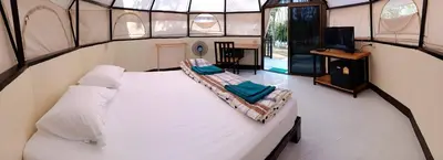 a room with a bed and a tv in it at Camp Hadee Koh Yao Noi in Ko Yao Noi