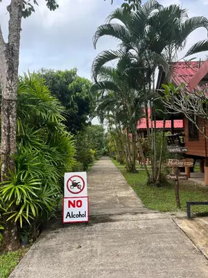 a no alcohol sign on the side of a sidewalk at Najjamee Bungalows in Ko Yao Noi
