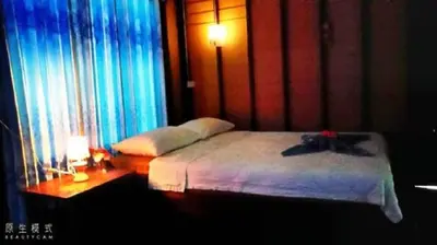 a bedroom with a bed and a window with curtains at Najjamee Bungalows in Ko Yao Noi