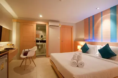 a bedroom with a bed with towels on it at Ratana Platinum Resort Kamala in Kamala Beach