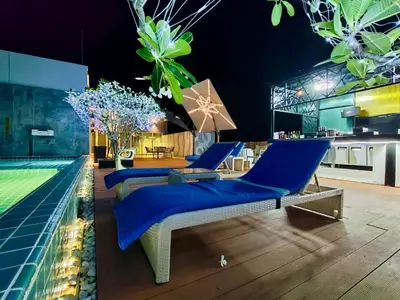 a villa with a swimming pool with blue furniture at Ratana Platinum Resort Kamala in Kamala Beach