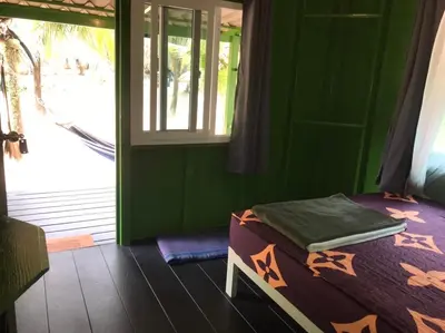 a green room with a bed and a window at Suan Proud Koh yao noi in Ko Yao Noi