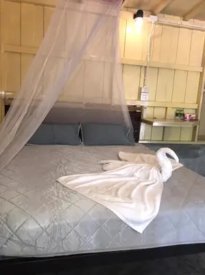 a white swan laying on top of a bed at Suan Proud Koh yao noi in Ko Yao Noi
