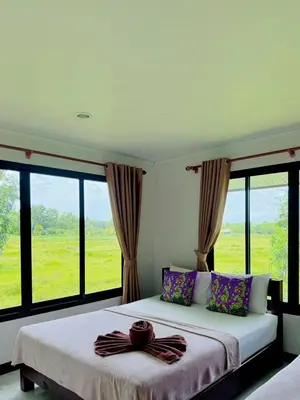 a bedroom with a large bed with large windows at Bang Mee Homestay Koh Yao Noi in Ko Yao Noi
