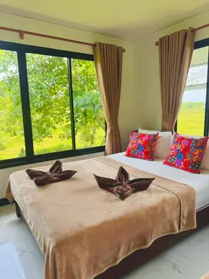 two beds in a room with large windows at Bang Mee Homestay Koh Yao Noi in Ko Yao Noi
