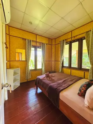 a bedroom with a large bed in a room with windows at Bang Mee Homestay Koh Yao Noi in Ko Yao Noi