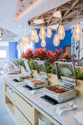 a buffet line in a restaurant with pendant lights at BlueSotel SMART Krabi Aonang Beach - Adults only in Ao Nang Beach