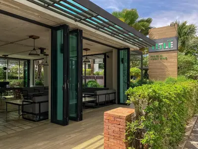 a patio with tables and chairs and a building at Title Rawai Phase III by Beringela in Rawai Beach